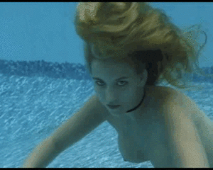 Blonde girl holding breath underwater